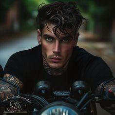 a man with tattoos on his arms and shoulder sitting on a motorcycle looking at the camera