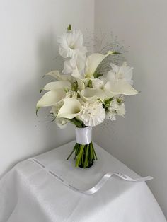 a vase filled with white flowers on top of a table