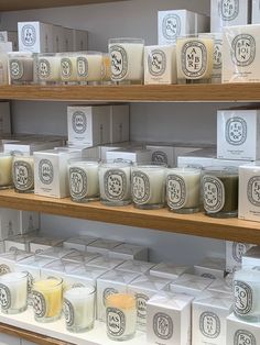 many different types of candles on shelves in a store