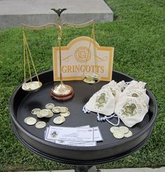 a black table topped with lots of gold coins and a sign that says grinoot's