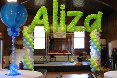 an indoor area decorated with balloons and streamers that spell out the word'pizza '