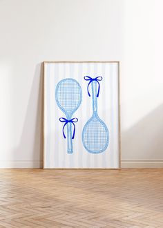 two tennis racquets are hanging on the wall next to a wooden floor