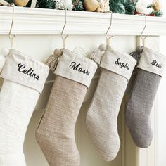 three stockings hanging from a mantel decorated with christmas ornaments and personalized name on them