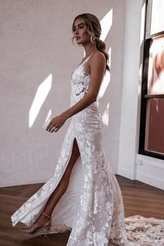 a woman in a white wedding dress standing on a wooden floor with her leg up