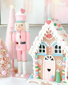 a nutcracker is standing next to a gingerbread house