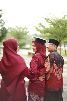 three people dressed in traditional garb standing next to each other on a brick walkway