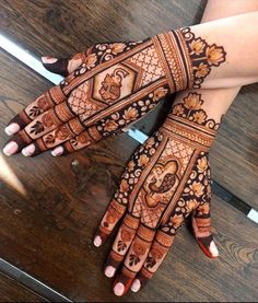 two hands with henna designs on them, one is showing off the intricate design