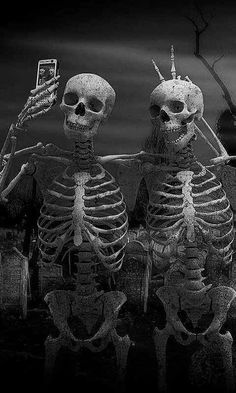 two skeletons sitting next to each other in the dark