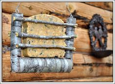 a bird feeder hanging from the side of a wooden wall