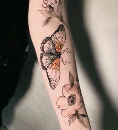 a woman's arm with flowers and butterflies on it