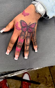 a woman's hand with butterfly tattoos on it