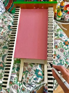 a person is painting on an easel with pink paper and black and white stripes