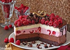 a piece of cake with raspberries on top and chocolate shavings around it