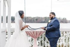 a bride and groom hold hands at the end of their wedding ceremony by the water