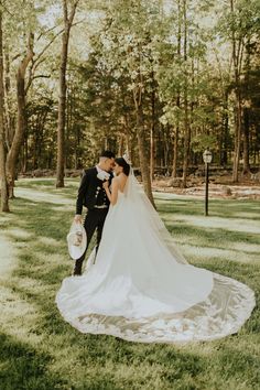 a bride and groom standing in the grass