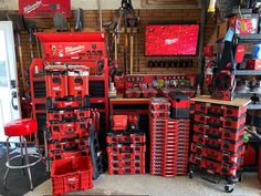 a room filled with lots of red tool boxes next to a tv on top of a wall