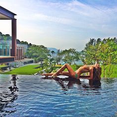 a woman laying on the edge of a swimming pool