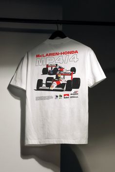 🏁 Celebrate racing history with FirstGears' McLaren MP4-4 Racing T-Shirt. This original art car shirt features a poster-type design perfect for birthdays, car enthusiasts, or as a special gift for Dad. Whether you're a fan of McLaren, Formula 1, or just love iconic racing cars, this shirt is for you! Crafted from 100% organic cotton, this shirt offers superior comfort with a vintage feel. It features a custom FirstGear neck tag, striking front and back design, and seamless sides knitted in one Formula 1 Shirt Design, Vintage Car Shirts, F1 Shirt Design, Car Shirt Design, Motorsport Apparel, Racing Shirt Design, Formula 1 Shirt, Gifts For Car Guys, Design For Birthday