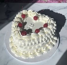 a heart shaped cake with cherries on top