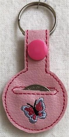 a pink leather key chain with a butterfly on it