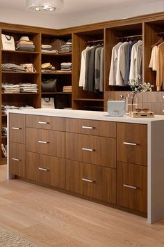 an organized closet with wooden cabinets and drawers