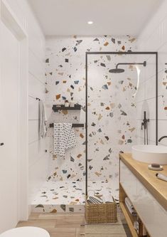 a bathroom with a shower, sink and toilet in it's center wall is decorated with multicolored tiles