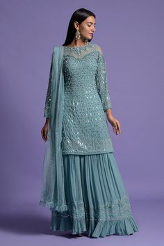 Metallic blue kurta with sequin, cut bead, pearl embroidery. Paired with sharara and dupatta.
Components:3
Pattern:Embroidery
Type of Work:Sequin, cut bead, pearl
Neckline:Closed boat neck
Sleeve Type:Long sleeves
Fabric:Viscose
Color:Blue
Other Details:
Ruffle dupatta
Back tassel tie-up
Occasion:Sangeet - Aza Fashions Sharara Designs Latest, Blue Sharara, Ruffle Dupatta, Sharara Designs, Desi Dress, Sangeet Outfit, Kurta Sharara Set, Lace Suit, Pakistani Formal Dresses