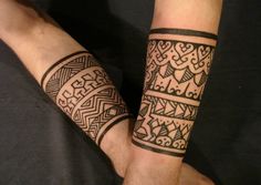 two people holding hands with tattoos on their arms and wristbands, both showing the same pattern