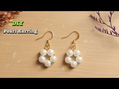 earrings with pearls hanging from them on a table