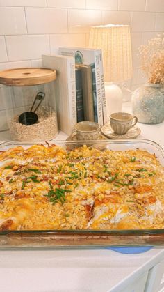 a casserole dish is sitting on a table next to books and other items