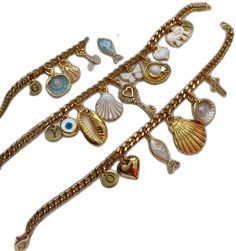 a gold bracelet with charms and seashells on it