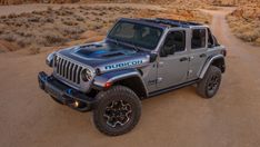 a jeep is parked in the desert near some rocks