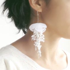 a close up of a person wearing some kind of earring with flowers on it