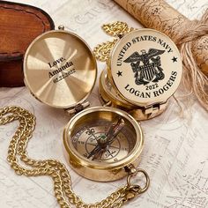 two gold compasses sitting on top of a map next to a corkscrew