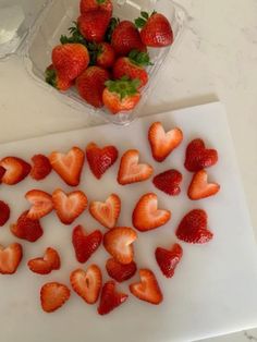 strawberries are cut up and placed on a cutting board