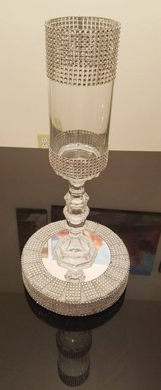 a crystal vase sitting on top of a black table next to a white and gray wall