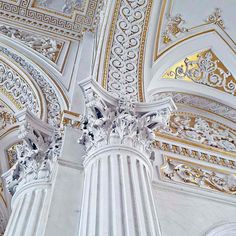 an intricately decorated ceiling with gold and white paint on the walls, along with ornate columns