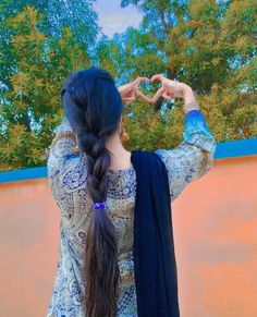 a woman making a heart shape with her hands