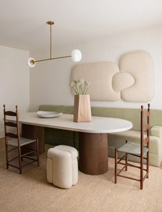 a dining room table with two chairs and a bench