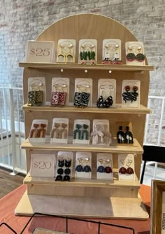 an assortment of earrings displayed on shelves in a room with brick wall and flooring