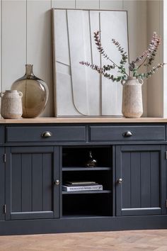 an entertainment center with two vases on top of it