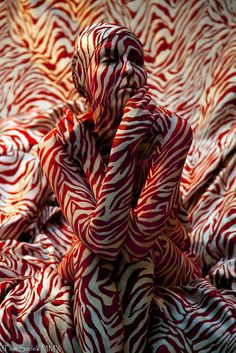 a person covered in red and white fabric