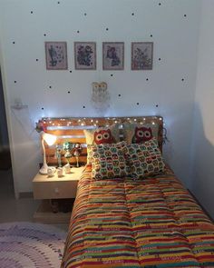 a bed with two pillows on top of it and some pictures above the headboard