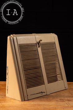 an old fashioned suitcase sitting on top of a wooden table