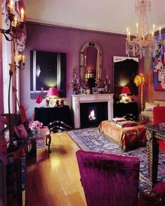 a living room filled with furniture and a fire place under a chandelier in front of a fireplace