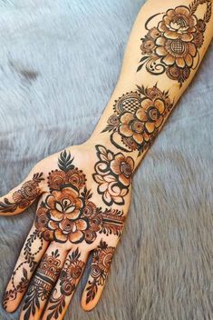 the hand is decorated with flowers and leaves