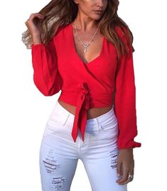 a woman wearing white jeans and a red top with a tie around the waist,