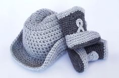 two crocheted hats and booties are shown on a white surface with one hat folded over the other