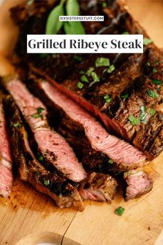 grilled ribeye steak on a wooden cutting board with green garnishes