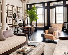 a living room filled with lots of furniture and pictures on the wall next to a window